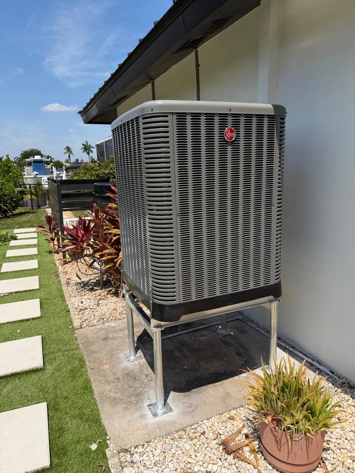 New Rheem condenser on an elevated stand after a replacement