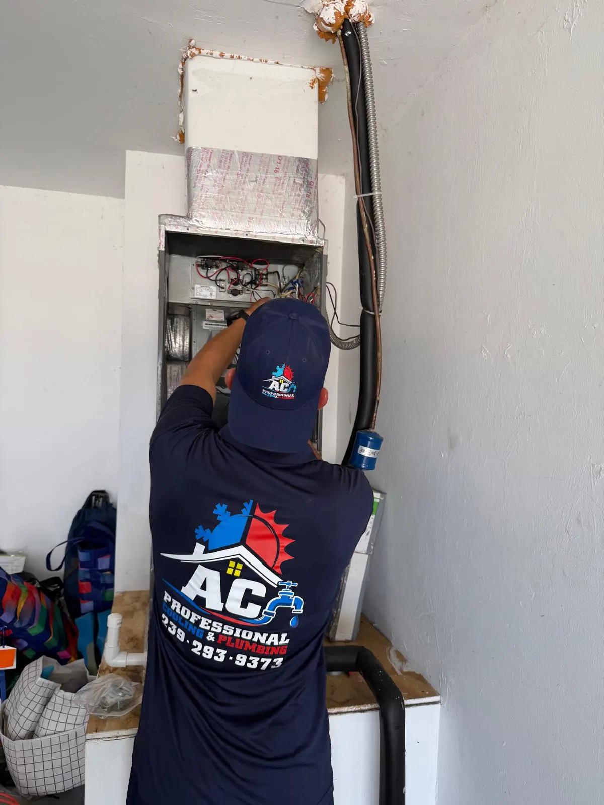 AC Professional technician checking an air handler inside a Southwest Florida home
