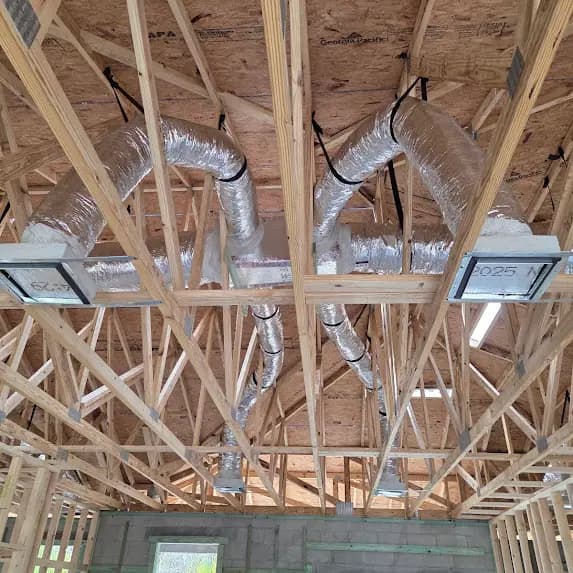 Insulated ducts and ceiling connections installed among open roof trusses