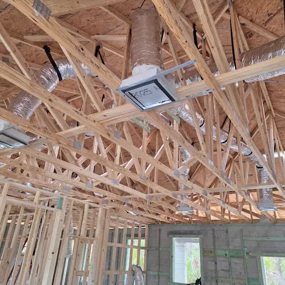 Flexible ductwork installed between roof trusses before drywall