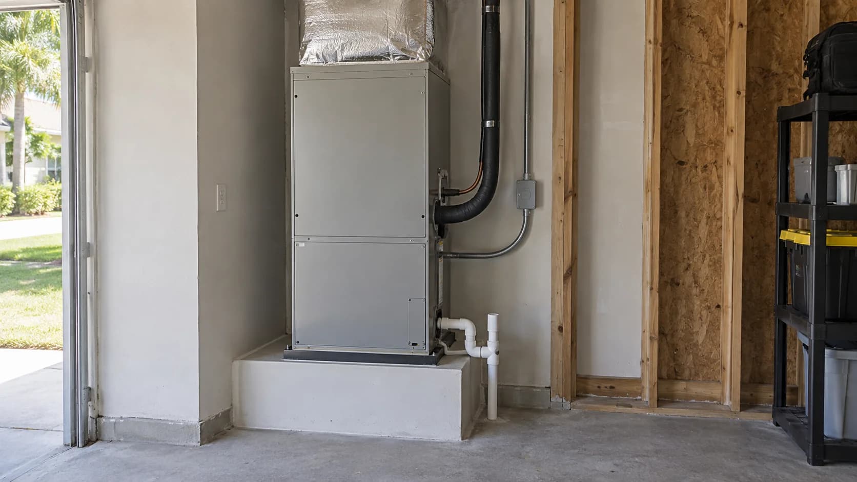 Indoor air handler with refrigerant connections and a PVC condensate drain in a mechanical alcove