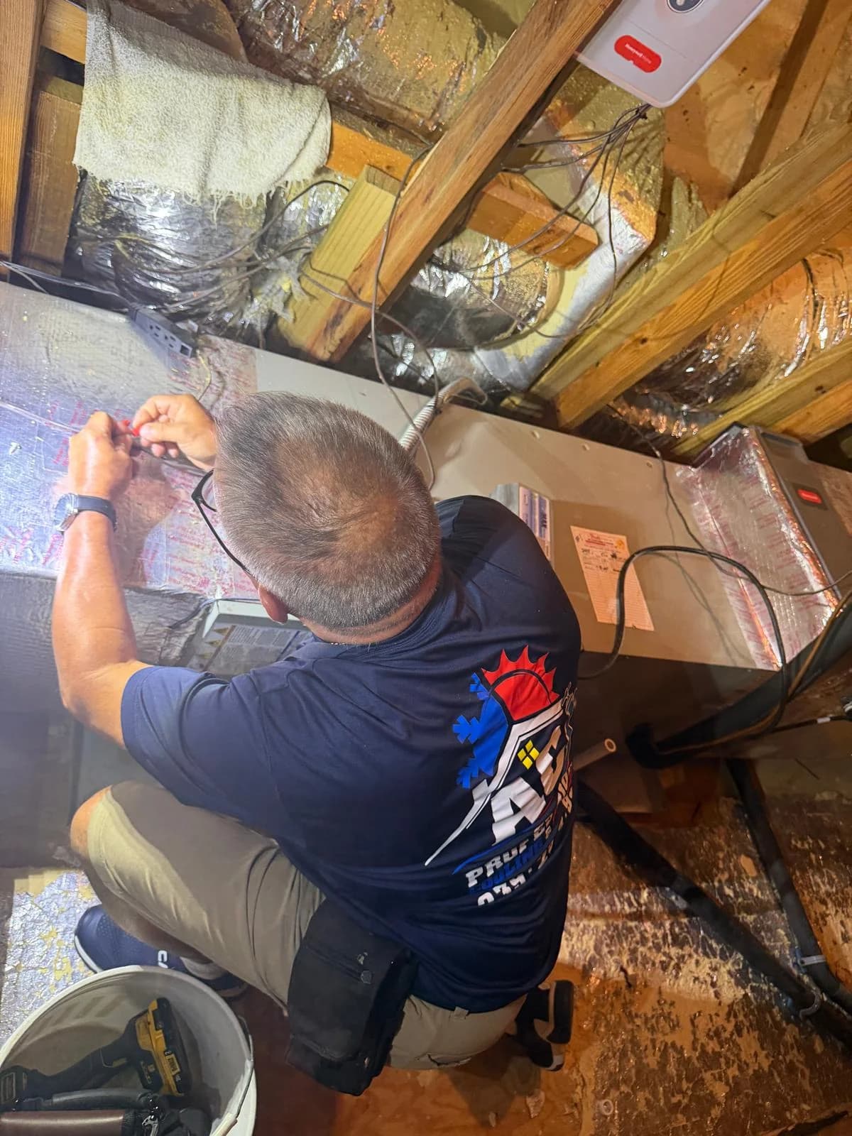 Técnico de AC Professional trabajando en una manejadora durante una instalación